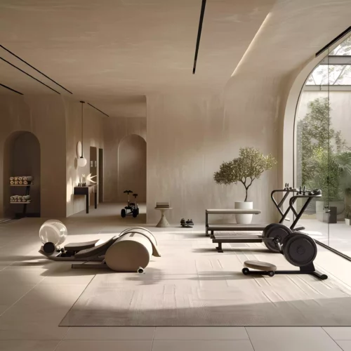 Moderner Fitnessraum mit Ergometer, Trainingsbank, Hanteln und großen Fenstern im Boutique Resort Maison Talmühle Schwarzwald