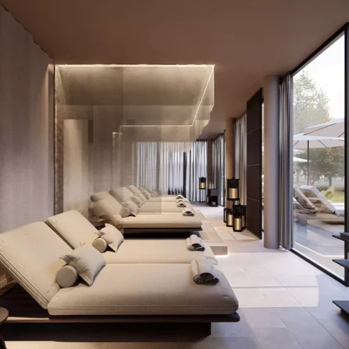 Helle Ruheliegen mit Kissen und Handtüchern in der Maison Talmühle Spa Lounge mit Blick auf Terrasse und Garten im