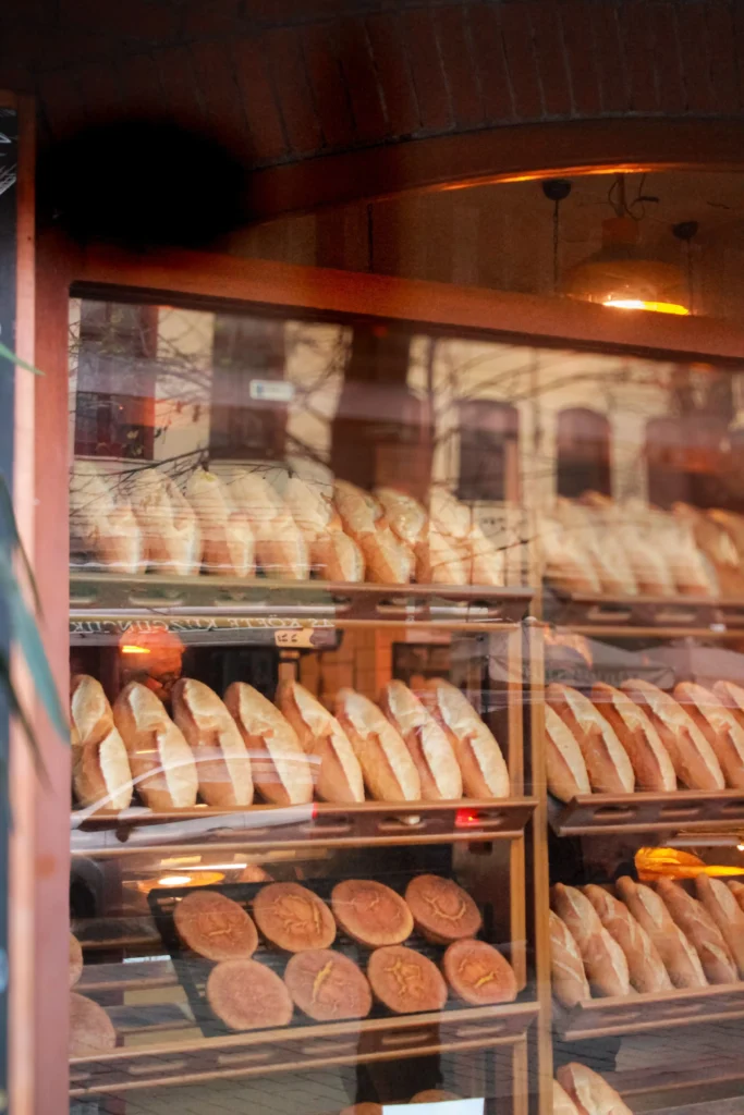 Blick durch Schaufenster auf Regale mit frisch gebackenem Brot in einer Boutique-Bäckerei im Schwarzwald.